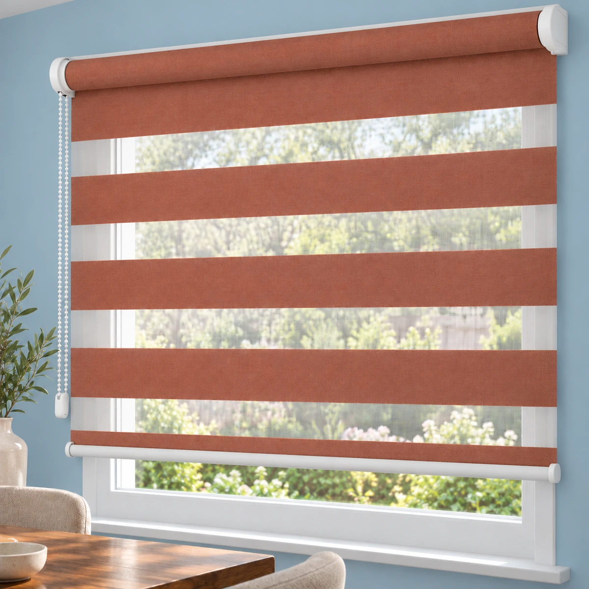 Terrakottafarbenes Doppelrollo ohne Kassette an einem weißen Fenster in Wandmontage über der Fensternische.